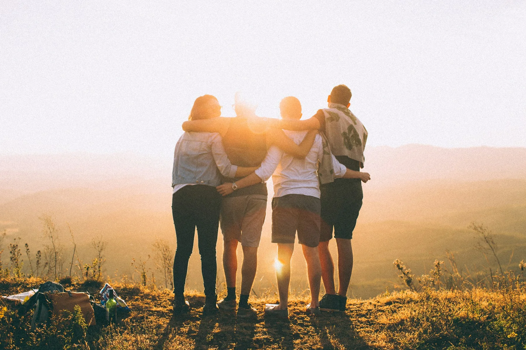 Cuatro personas comparten un paisaje al atardecer